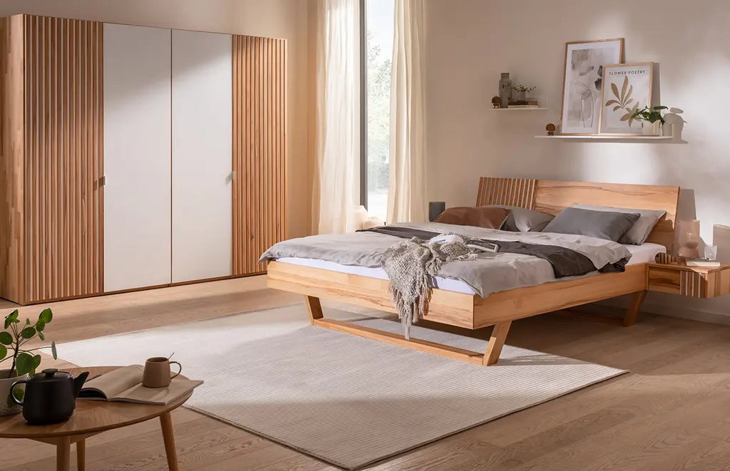 Schönes geräumiges Schlafzimmer mit Kleiderschrank und Bett aus Holz.